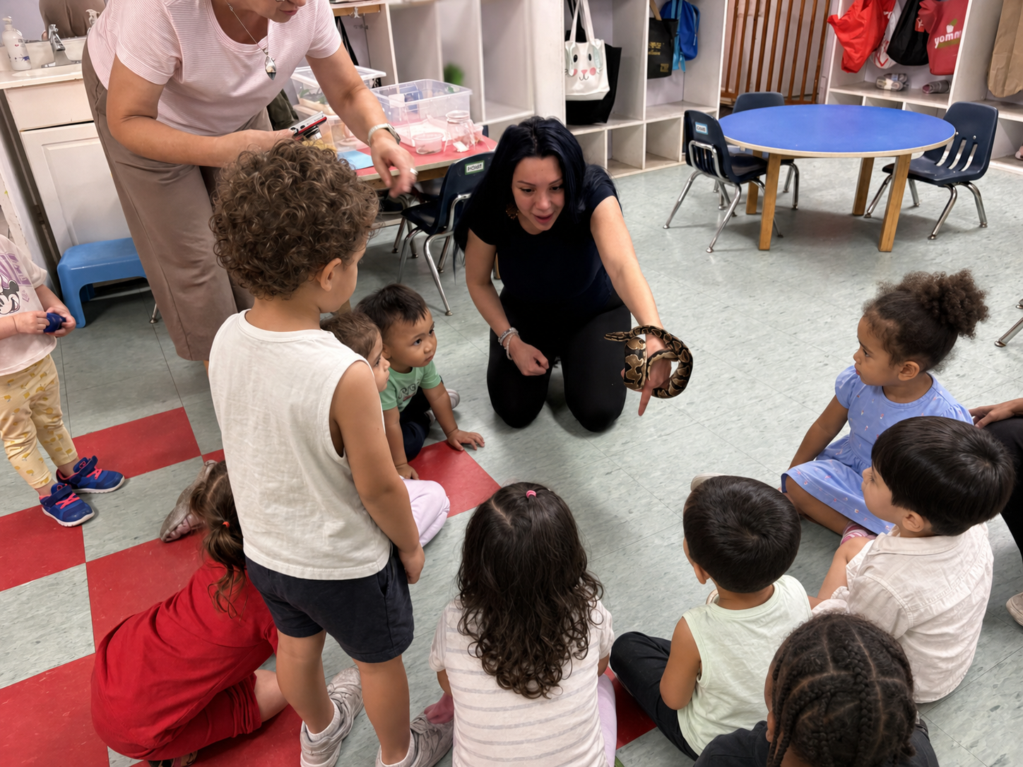 An educator sharing a ball python with a classroom group